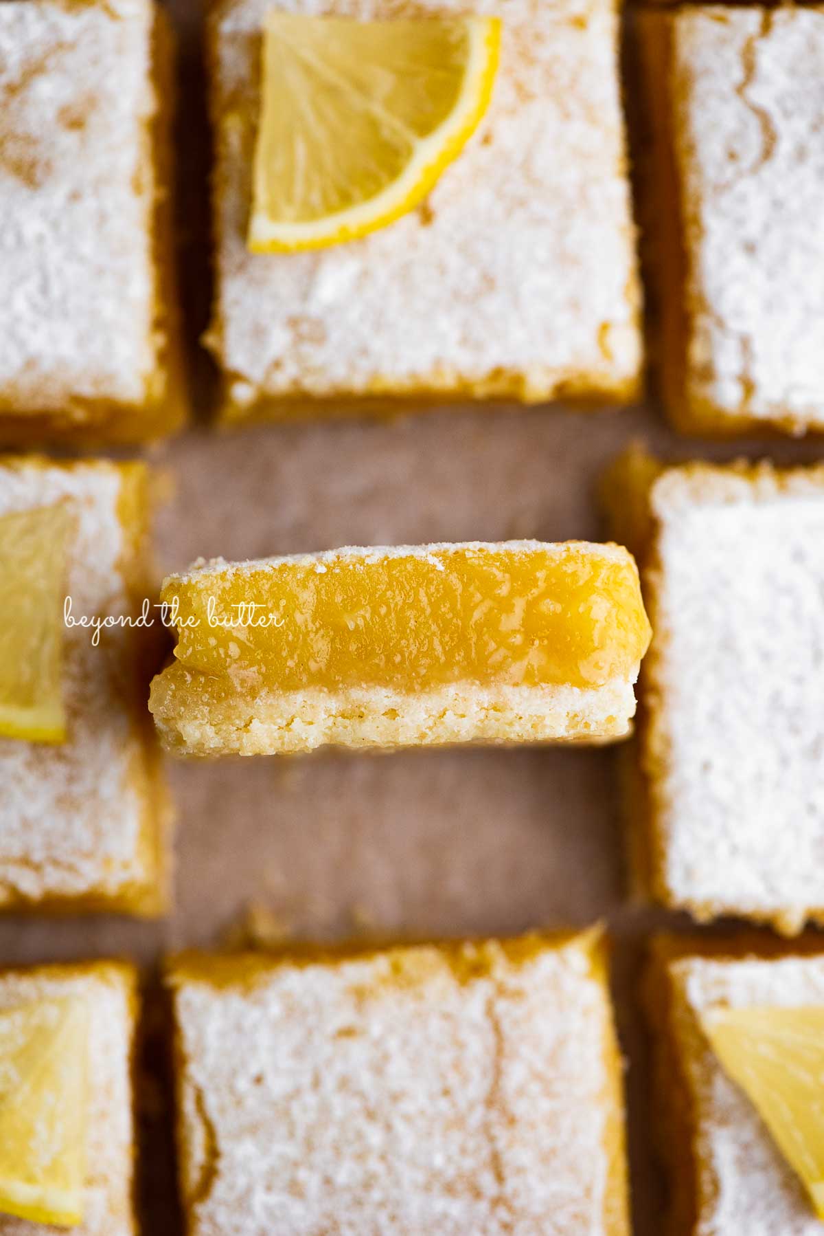 Sliced super easy lemon bars on parchment paper | © Beyond the Butter®