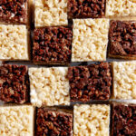 Chocolate-Vanilla Layered Rice Krispie Treats arranged like a checkered board pattern on white parchment paper.