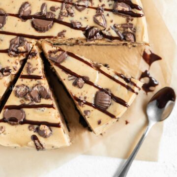 Close up overhead image of sliced Reese's Peanut Butter Cup Cheesecake drizzled with chocolate | All Images © Beyond the Butter, LLC