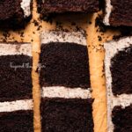 Slices of chocolate cake with oreo buttercream frosting on natural parchment paper.