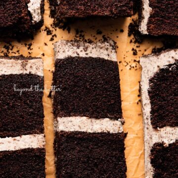 Slices of chocolate cake with oreo buttercream frosting on natural parchment paper from BeyondtheButter.com | © Beyond the Butter®