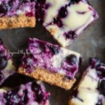 Sliced blueberry swirl cheesecake bars in a vintage baking pan.