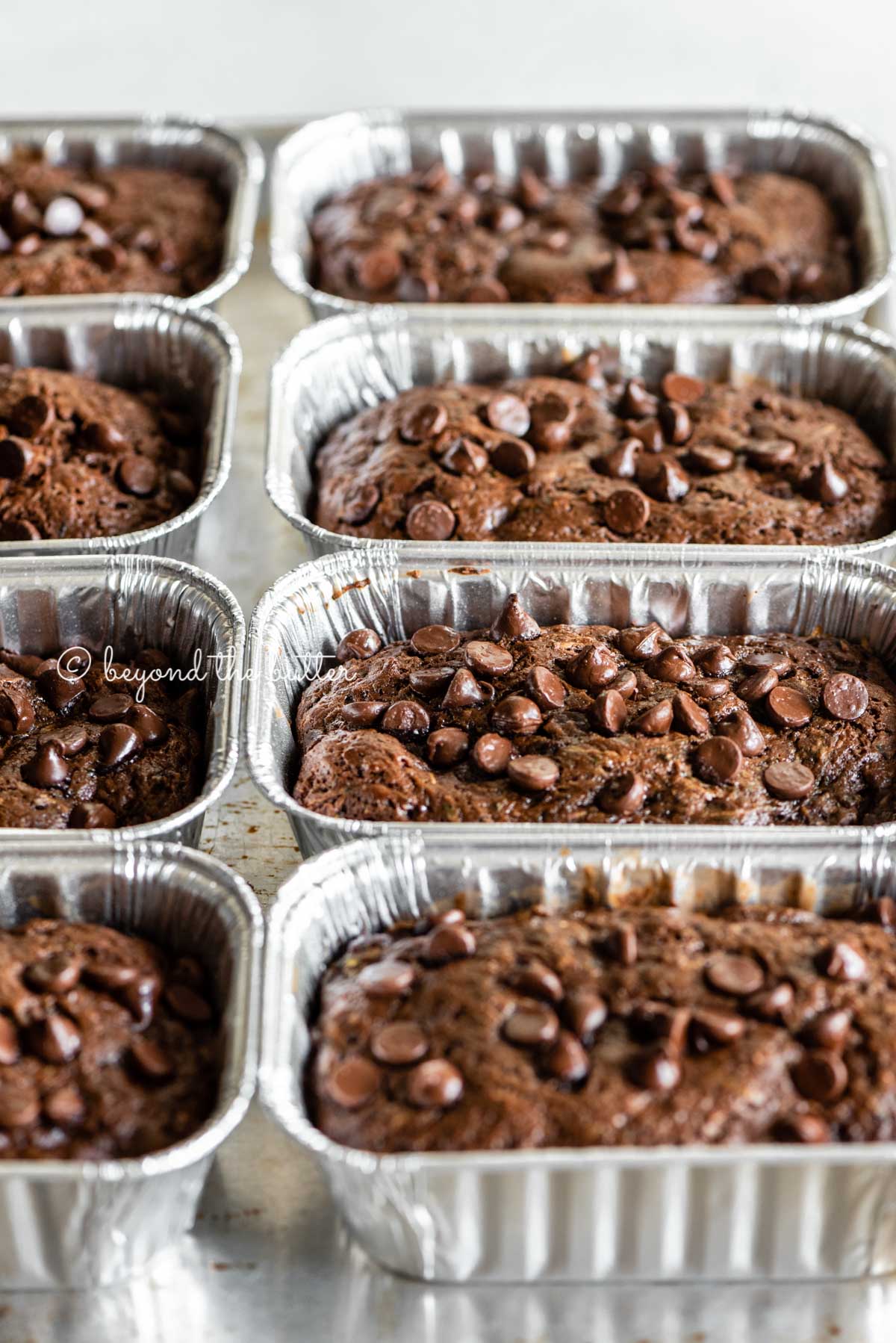 Angled image of mini chocolate zucchini bread loaves | All Images © Beyond the Butter™