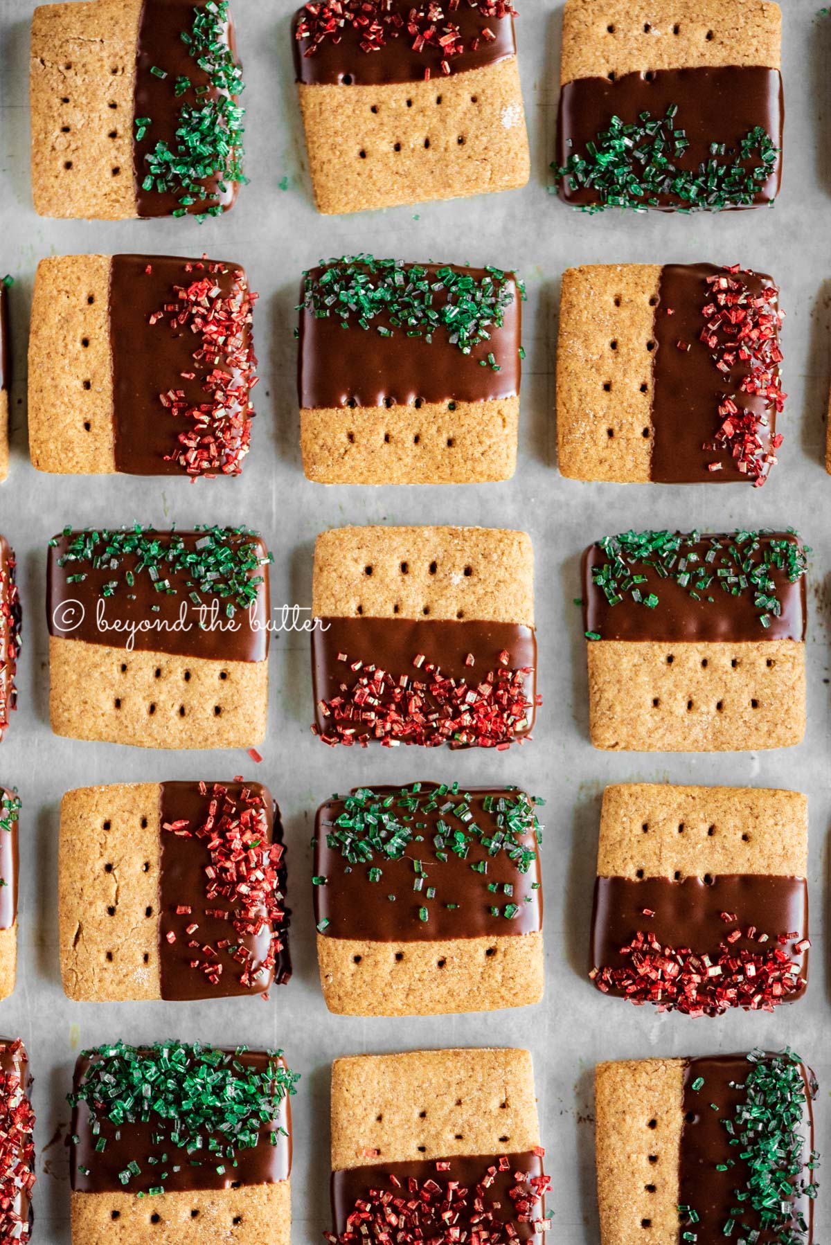 Cookie sheet with rows of Chocolate Dipped Graham Cracker Sqaures | © Beyond the Butter®