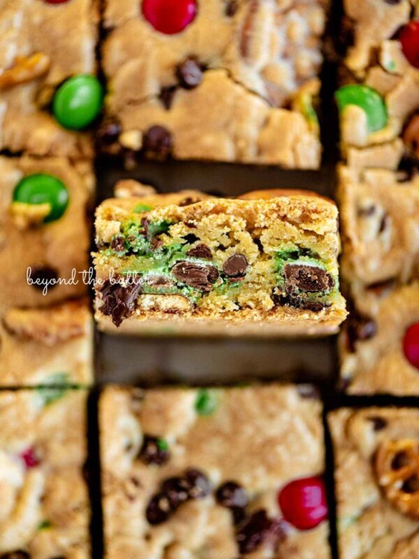 Chocolate chip cookie bars sliced into squares with the center bar on its side to see the soft chewy cookie center.