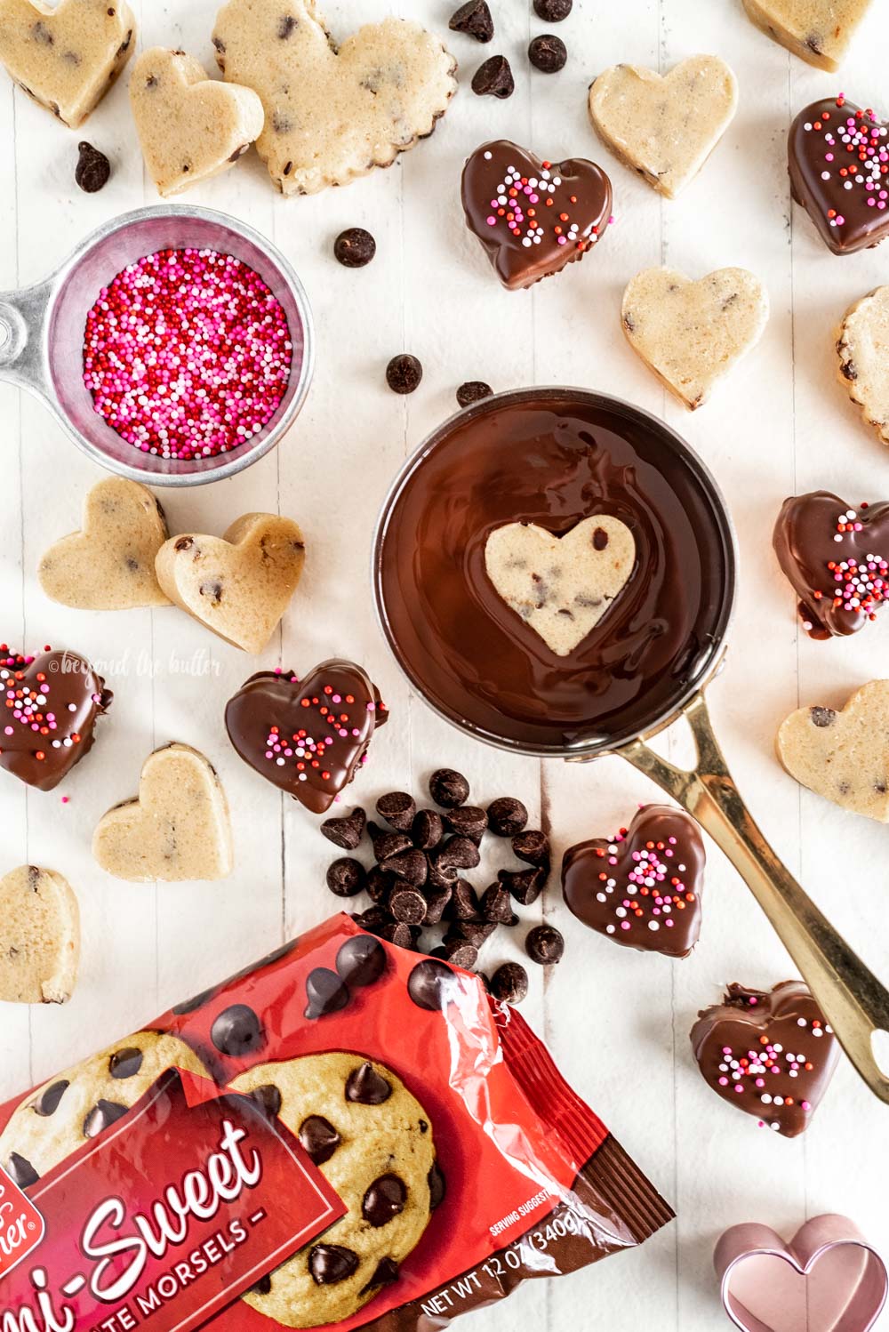 Dipping chocolate chip cookie dough hearts in melted chocolate | All Images © Beyond the Butter, LLC
