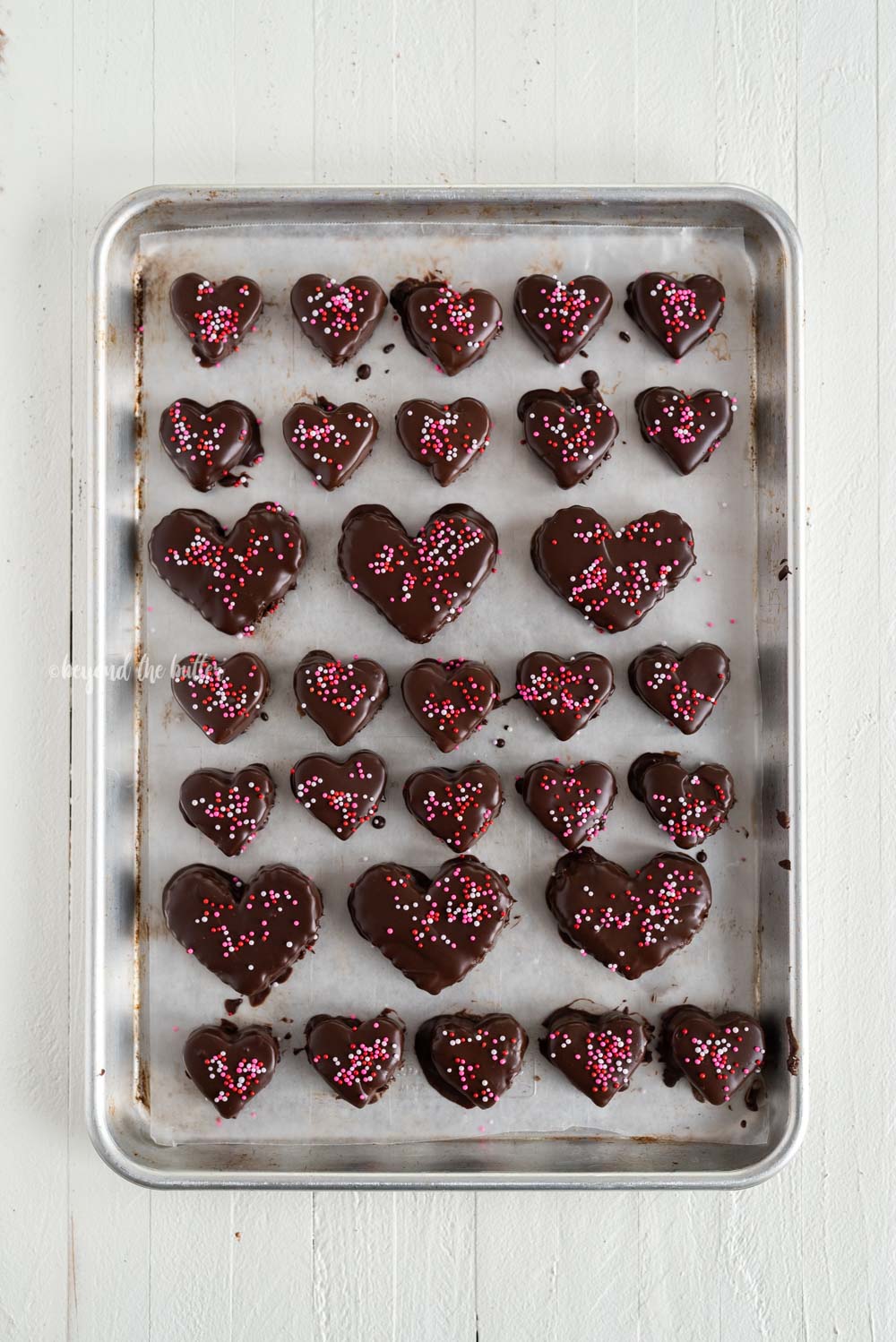 Overhead image of chocolate covered cookie dough hearts with sprinkles | All Images © Beyond the Butter, LLC