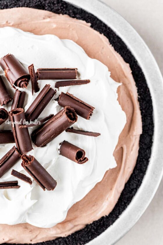 Overhead image of No-Bake Chocolate Cream Pie garnished with Cool Whip and chocolate curls | All Images © Beyond the Butter™