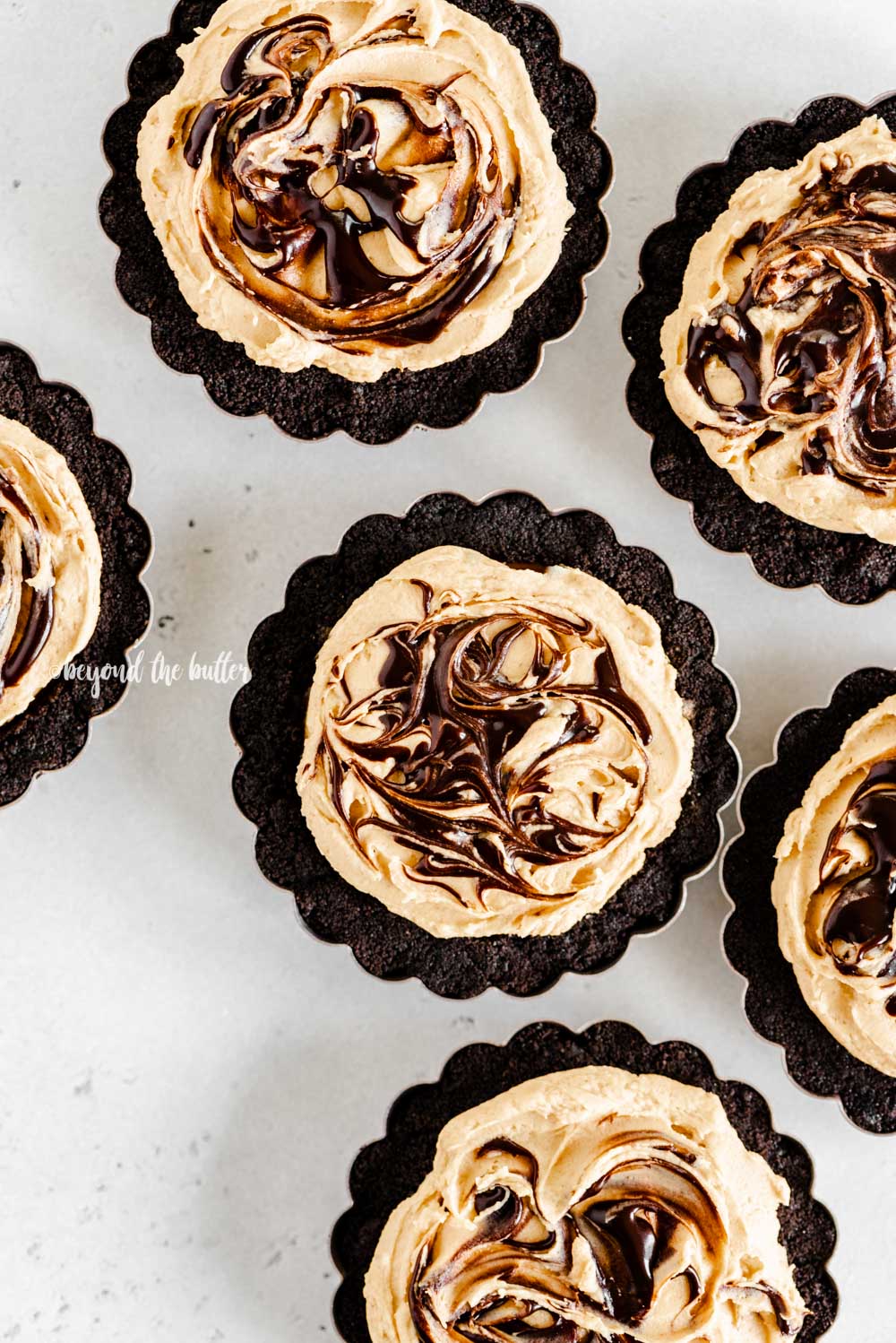 Overhead image of no bake mini chocolate peanut butter swirl tarts | All Images © Beyond the Butter™