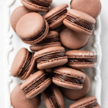 Overhead image of rectangular white plate full of chocolate macarons | All Images © Beyond the Butter™