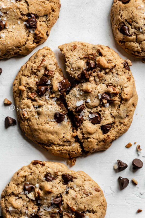 Overhead image of almond butter chocolate chip pecan cookies with the center cookie splitting in two | All images © Beyond the Butter™