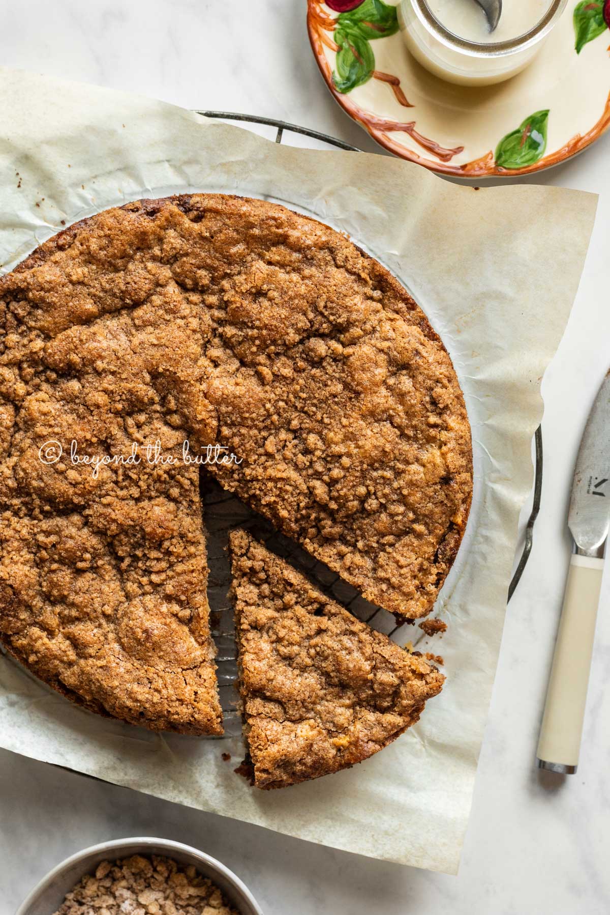 Image of apple coffee cake with slice cut and partially removed | All Images © Beyond the Butter™