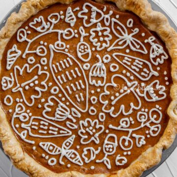 Overhead image of pumpkin pie with a piped cream cheese frosting decoration | © Beyond the Butter®