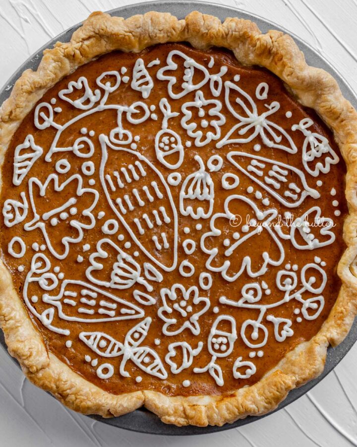 Overhead image of pumpkin pie with a piped cream cheese frosting decoration.