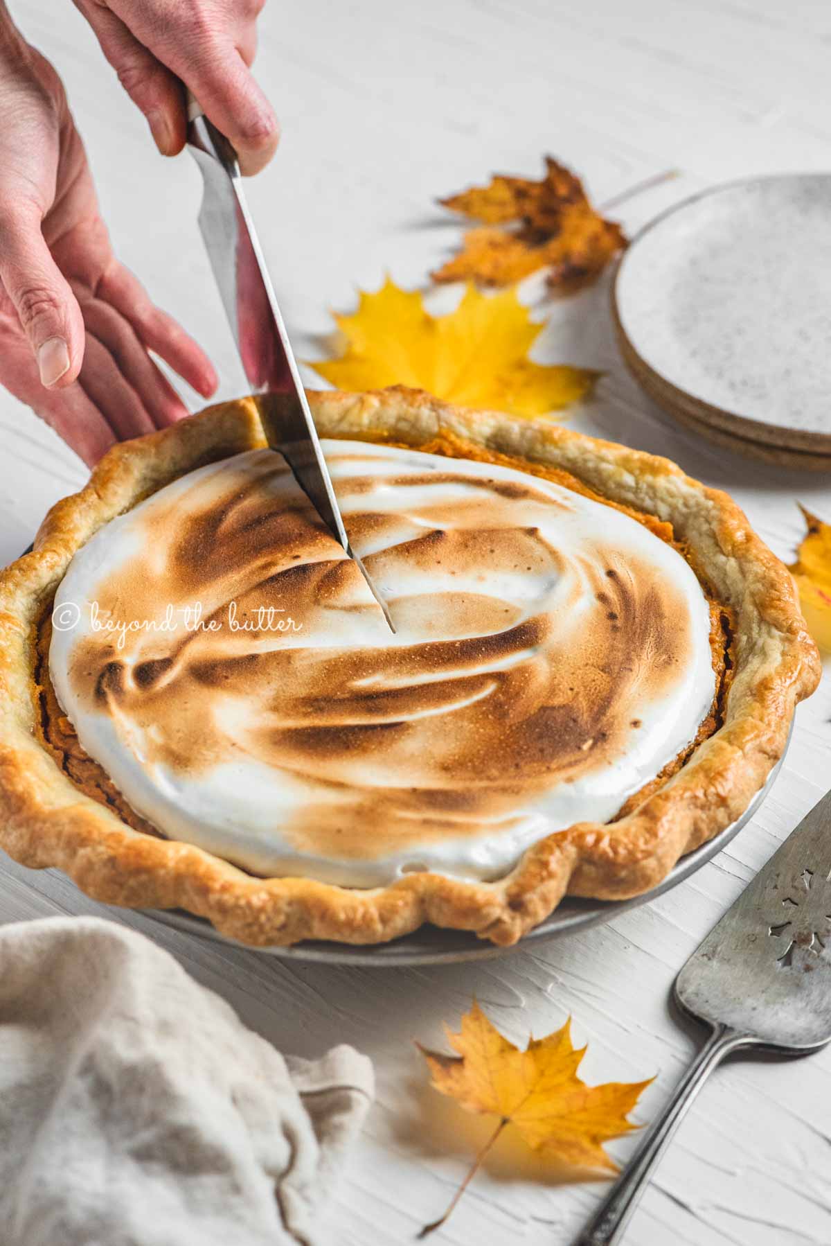 Cutting into the brown sugar sweet potato pie with pie server, plates, and napkin around it | | All Images © Beyond the Butter®