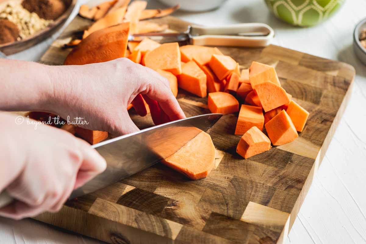 Cutting chunks of sweet potato for brown sugar sweet potato pie recipe from Beyond the Butter® | All Images © Beyond the Butter®