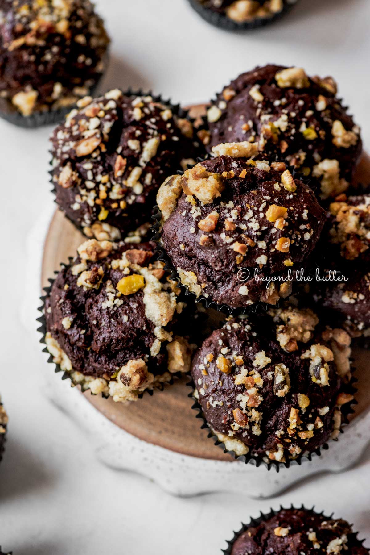 Small plate of dark chocolate pistachio cream cheese muffins on gray background | All Images © Beyond the Butter®