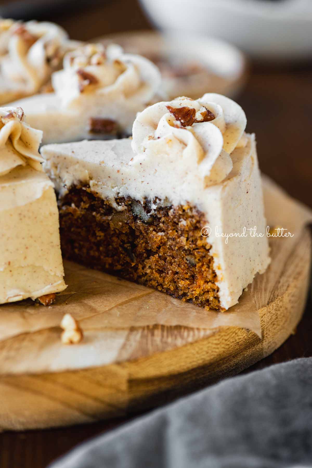 Angled closeup image of sliced 6 inch single layer carrot cake on parchment paper | All Images © Beyond the Butter®