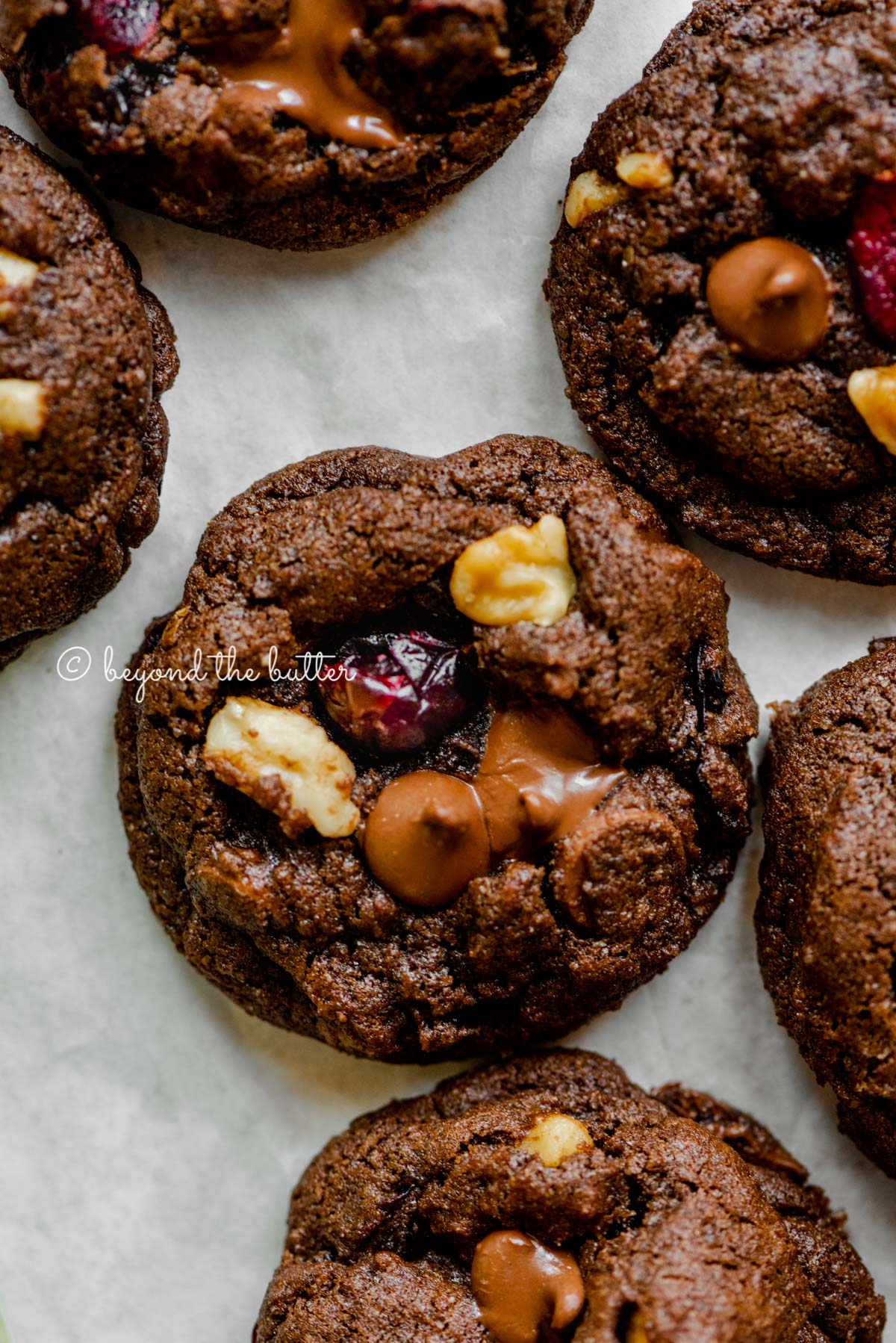 Dark chocolate cranberry walnut cookies on light gray background | All Images © Beyond the Butter®