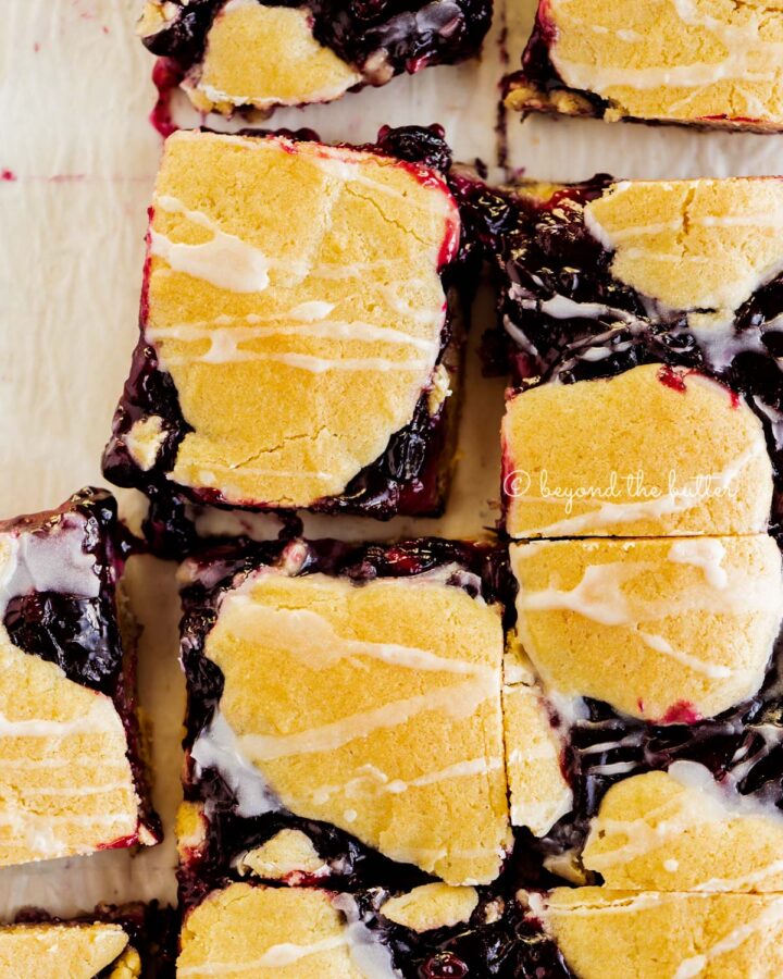 Blueberry swirl coffee cake squares on a white parchment paper background.