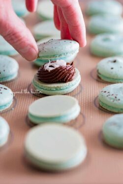 Sandwiching a robin's egg macaron shell together with another macaron shell | All images © Beyond the Butter®