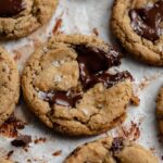 Small batch gluten-free peanut butter chocolate chunk cookies on a parchment paper lined baking sheet.