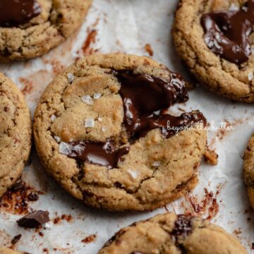 Small batch gluten-free peanut butter chocolate chunk cookies on a parchment paper lined baking sheet | © Beyond the Butter®