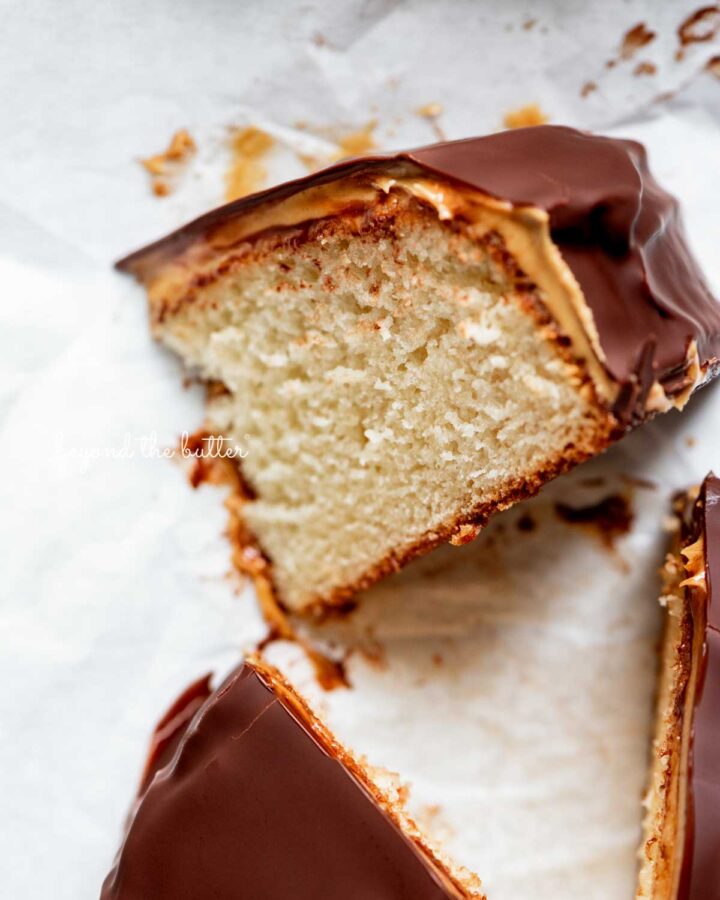 Small chocolate peanut butter tandy kake with a slice removed and placed on its side.