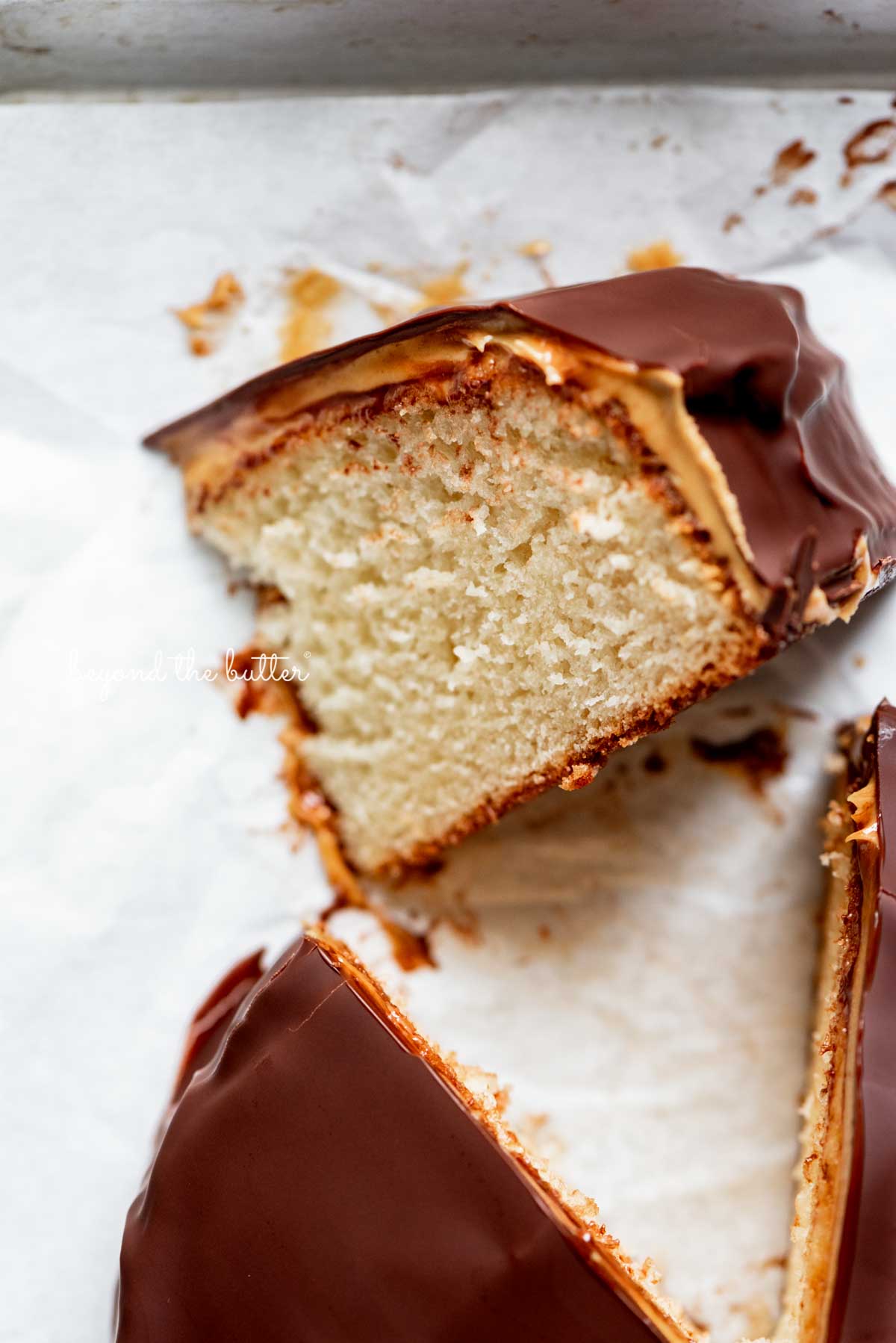 Small chocolate peanut butter tandy kake with a slice removed and placed on its side.