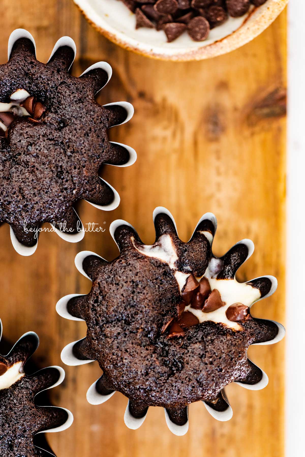 Small batch black bottom cupcakes on a wood cutting board | © Beyond the Butter®