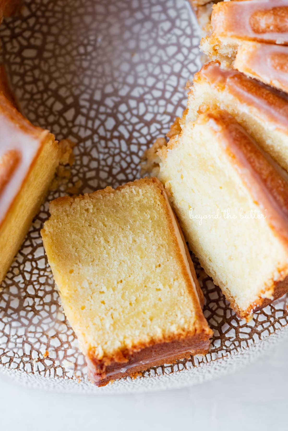 Sliced lemon cream cheese pound cake with a lemon glaze | © Beyond the Butter®