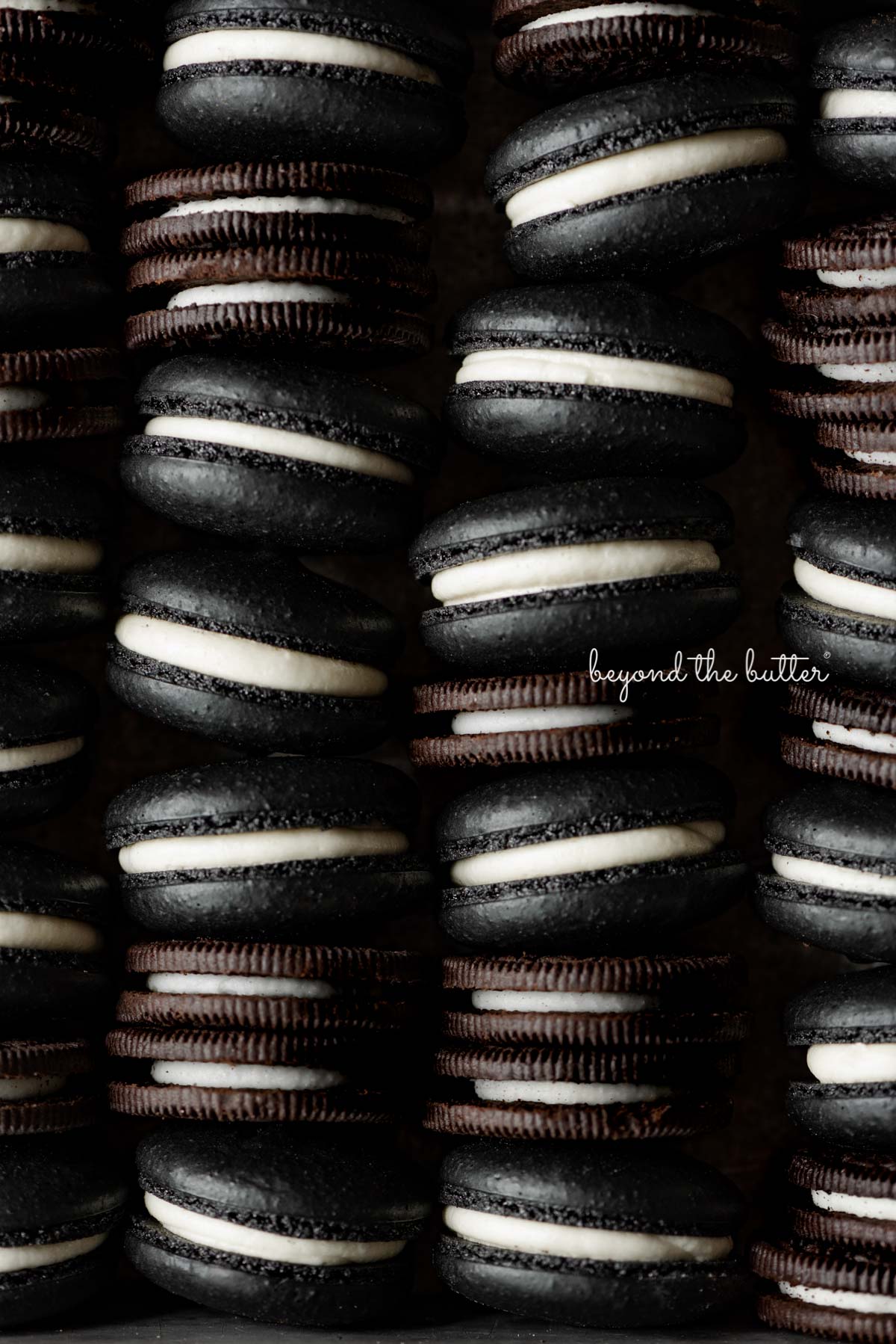 Stacked oreo macarons mixed with oreo cookies in a vintage baking tin | © Beyond the Butter®
