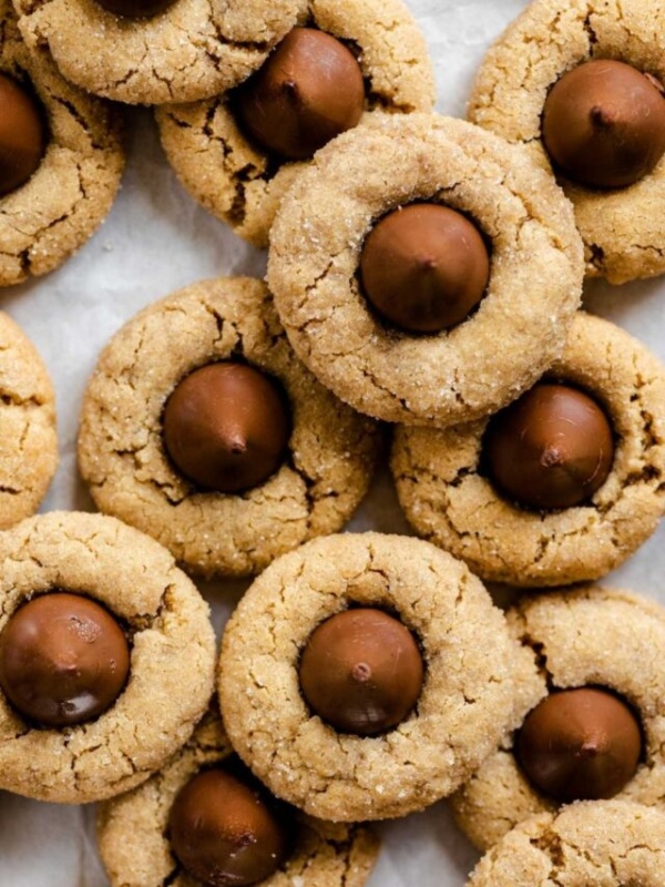 Peanut butter blossoms on a parchment paper lined baking sheet.