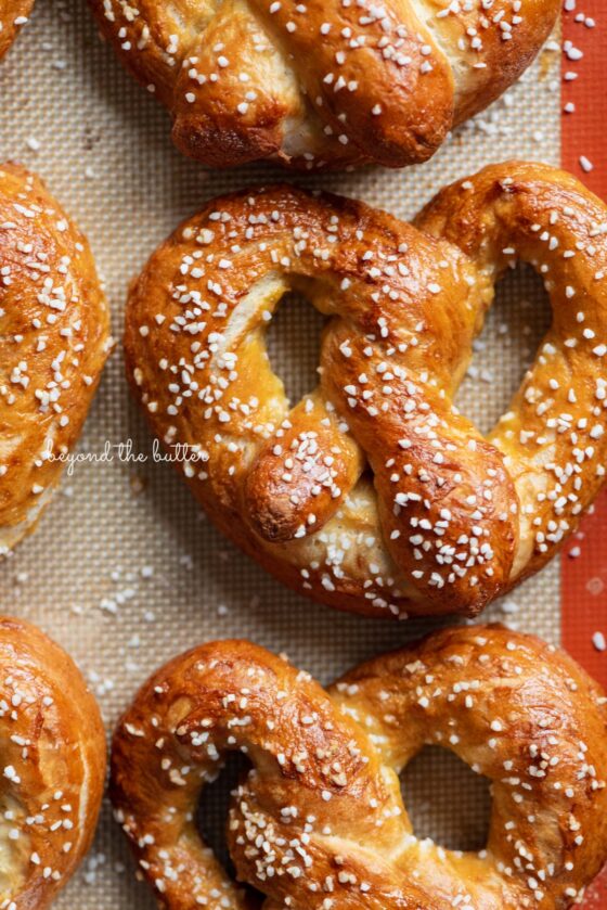 Homemade soft pretzels on a silicone baking mat and baking sheet | © Beyond the Butter®
