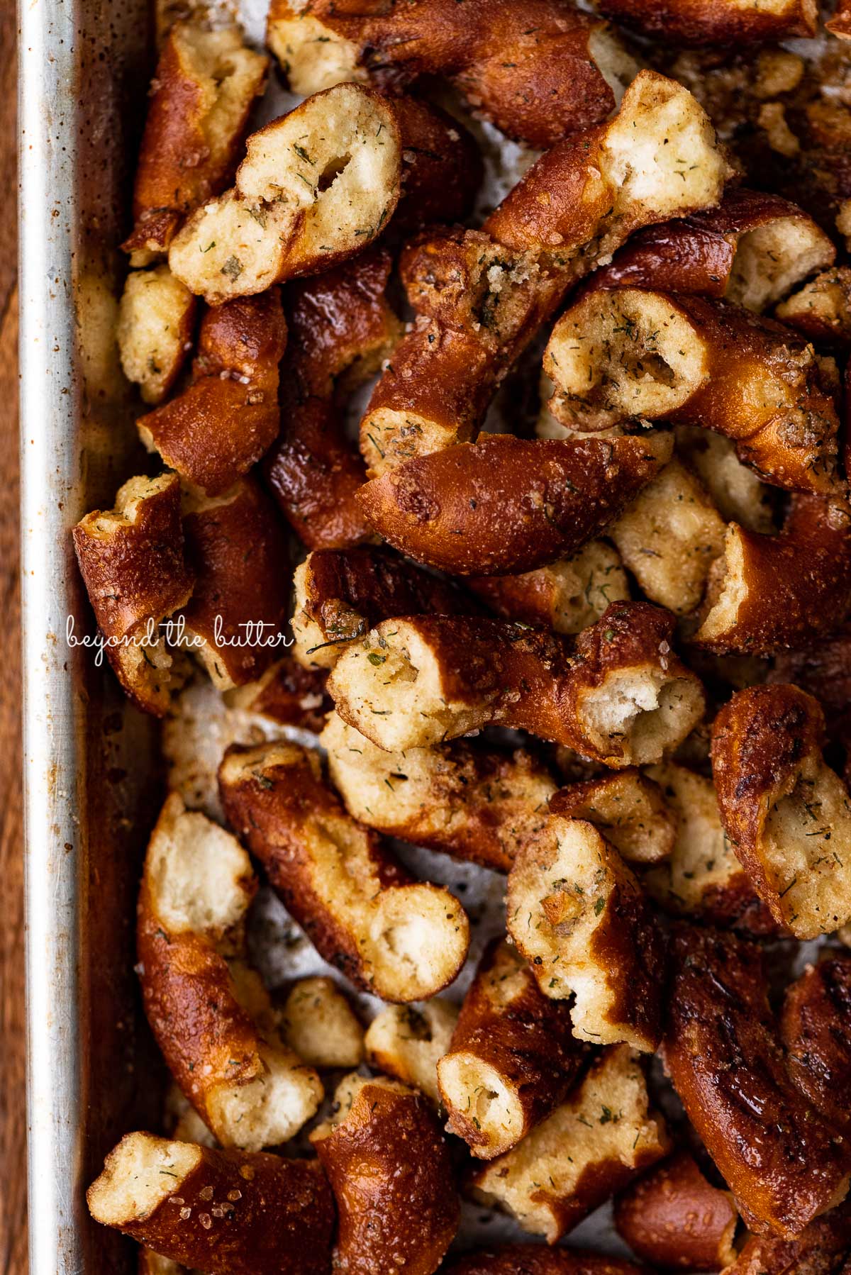 Baking sheet with just baked seasoned pretzels | © Beyond the Butter®