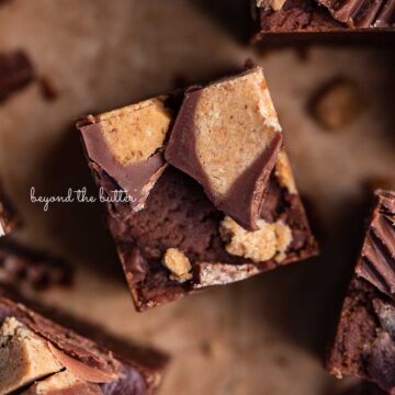 Sliced homemade chocolate peanut butter fudge on brown parchment paper | © Beyond the Butter®