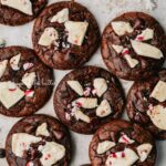 Just baked peppermint bark brownie crinkle cookies on a parchment paper lined baking sheet.