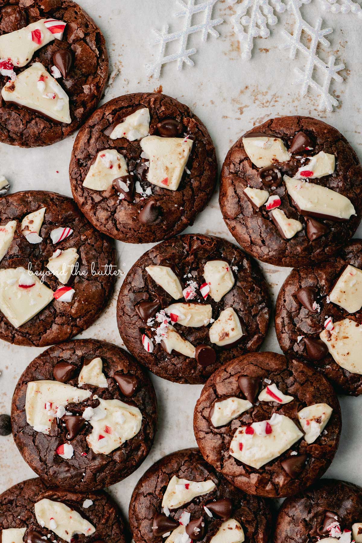 Just baked peppermint bark brownie crinkle cookies on a parchment paper lined baking sheet.