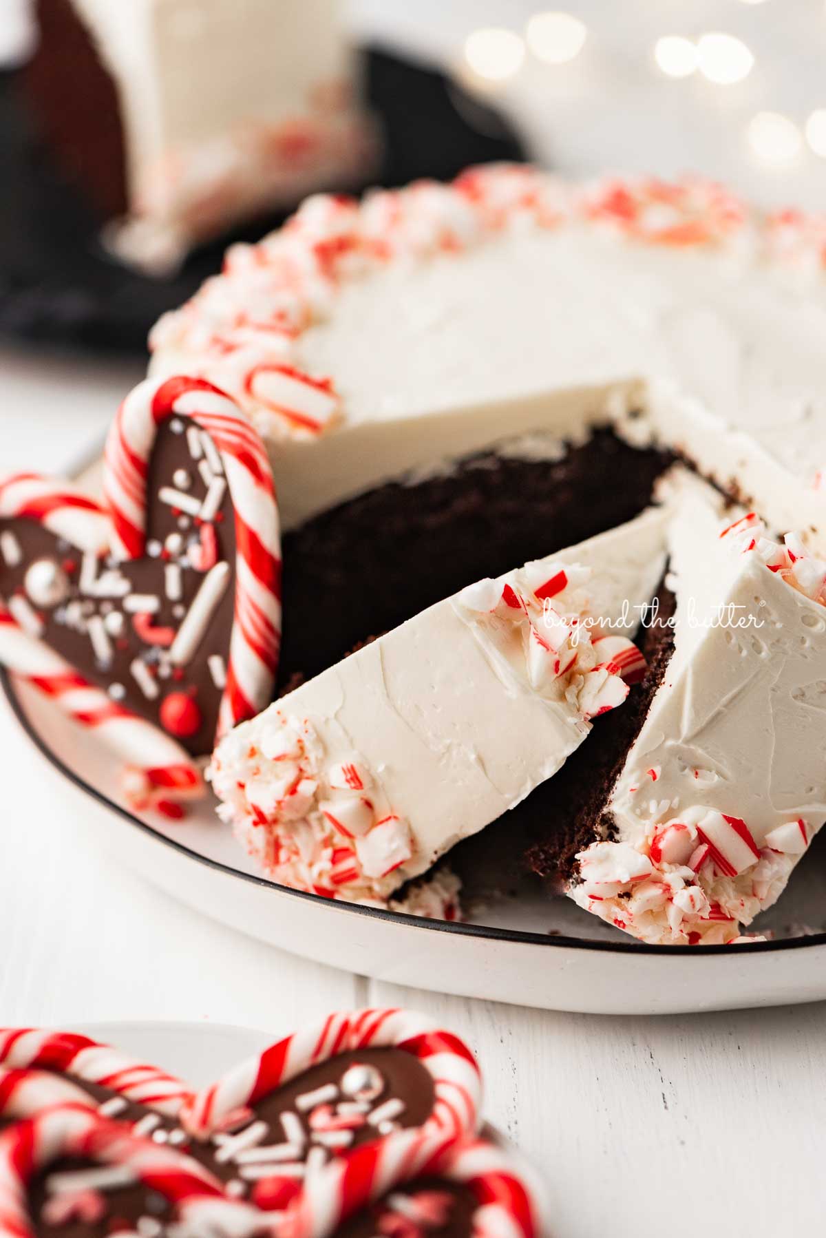 Single layer chocolate peppermint cake sliced with candy cane hearts placed on the dessert plate | © Beyond the Butter®