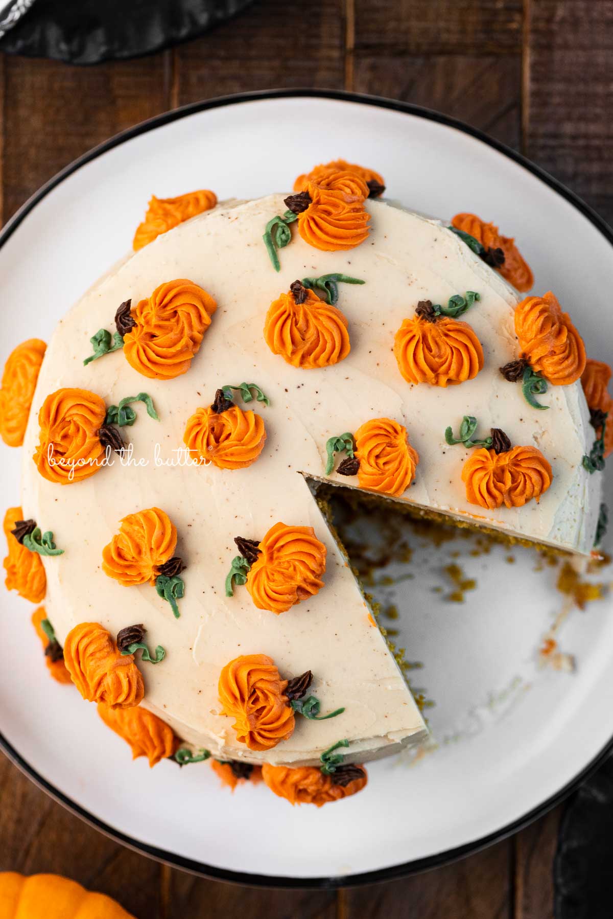Single layer pumpkin spice cake with slice removed on a black abd white dessert plate | © Beyond the Butter®