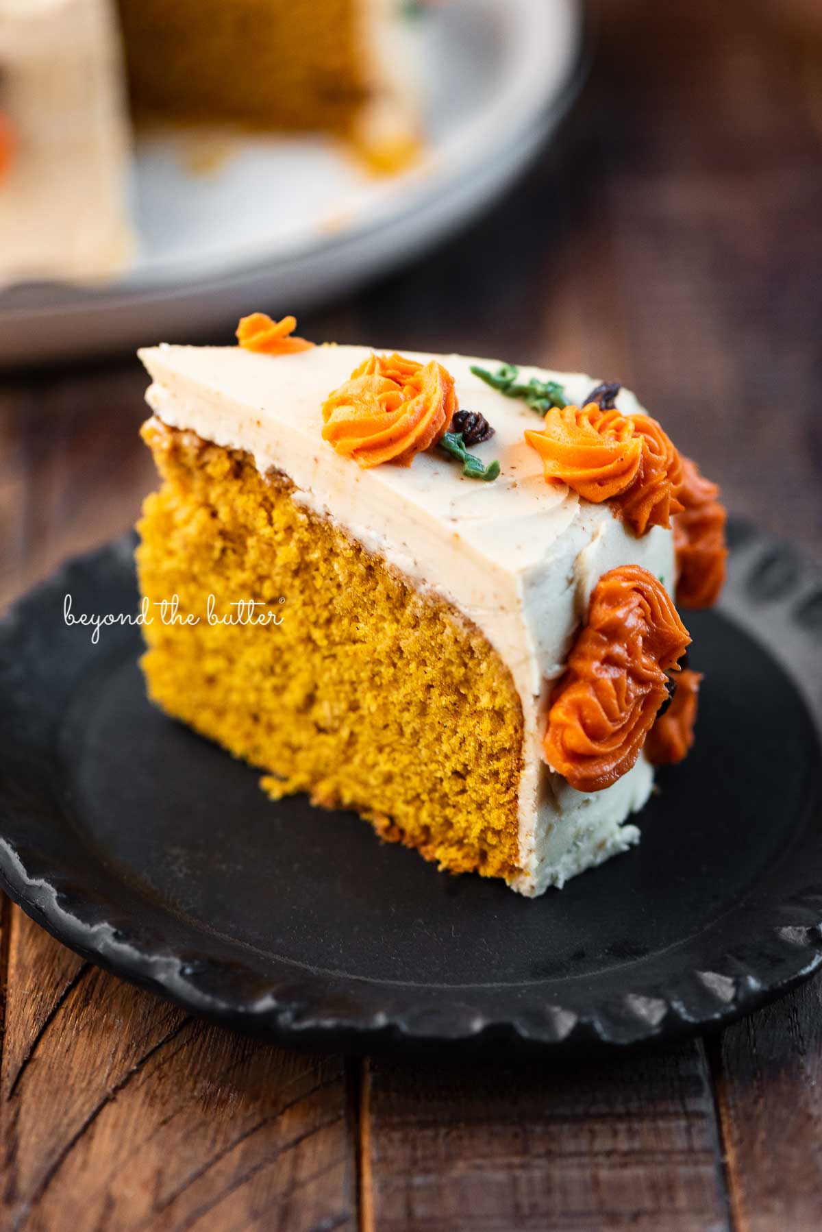 Slice of pumpkin spice cake on a small black dessert plate | © Beyond the Butter®