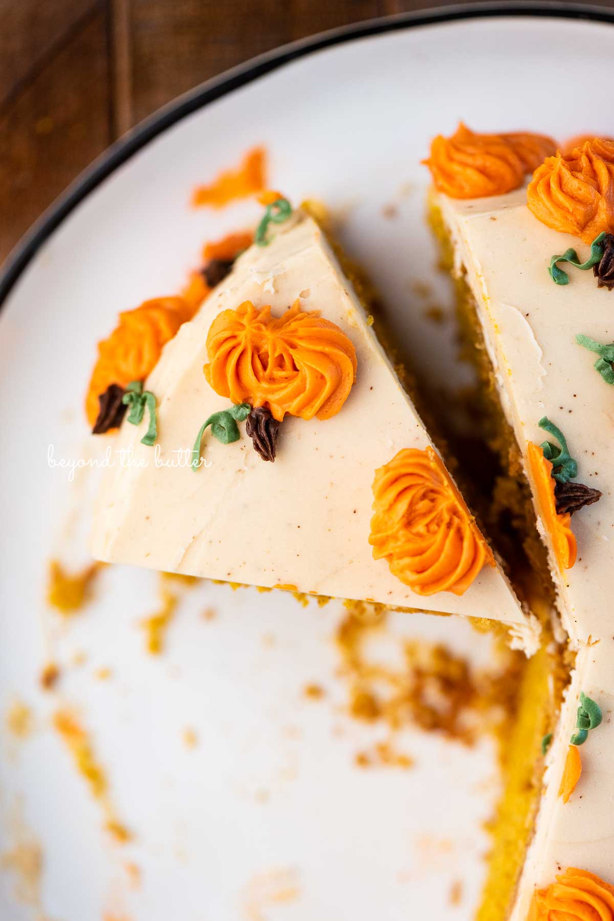 Cut slice of pumpkin spice cake on a black and white dessert plate | © Beyond the Butter®