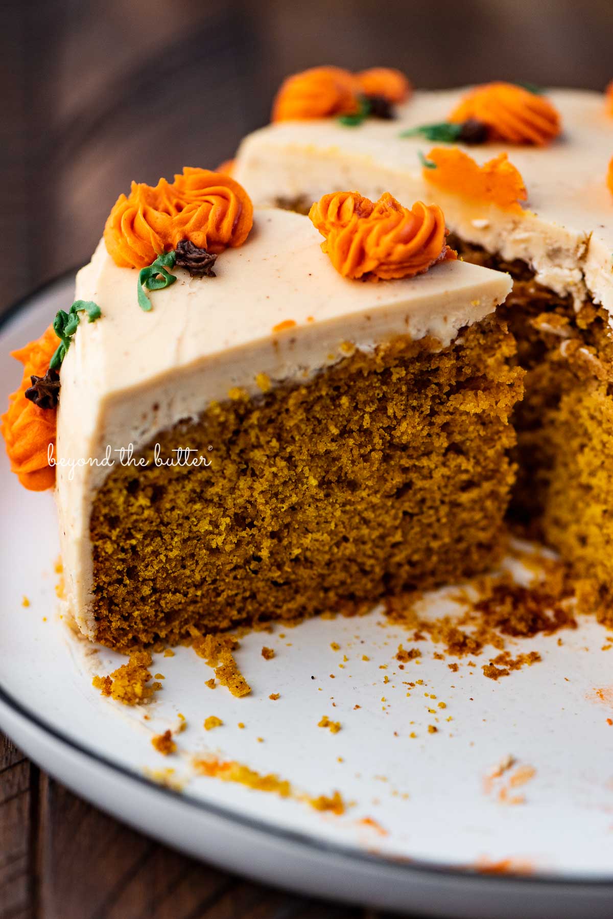 Slice of pumpkin spice cake on a black and white dessert plate | © Beyond the Butter®