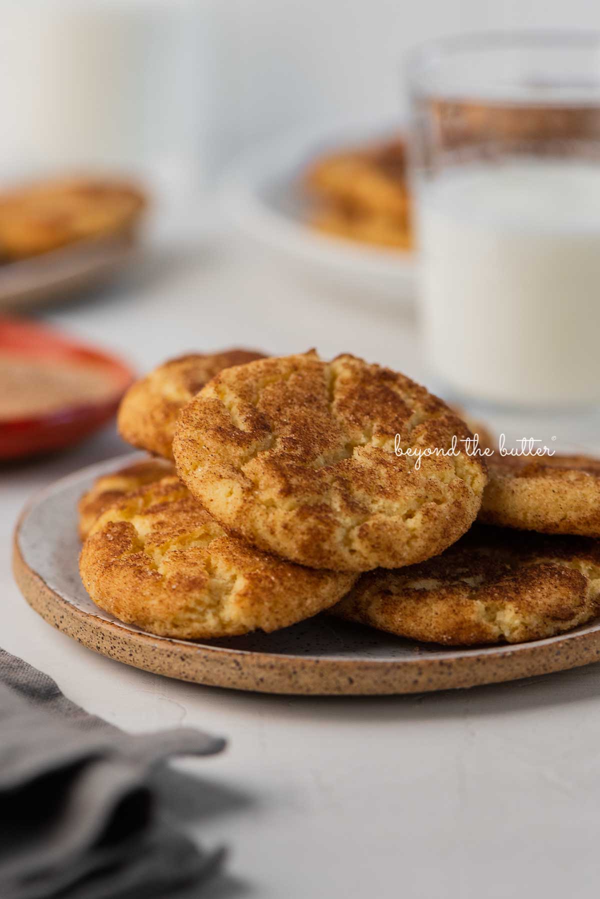Snickerdoodle cookies on a parchment paper lined baking sheet | © Beyond the Butter®