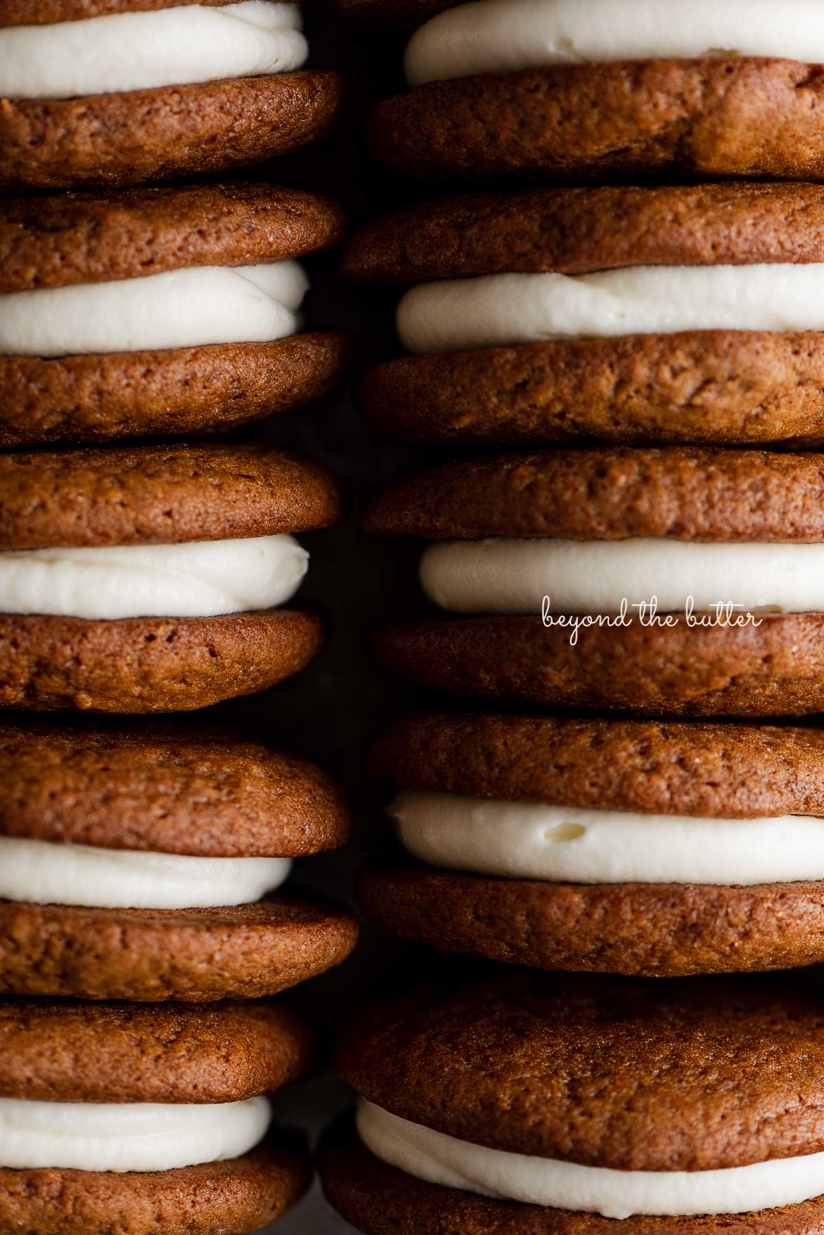 Stacked homemade gingerbread whoopie pies filled with cream cheese frosting | © Beyond the Butter®