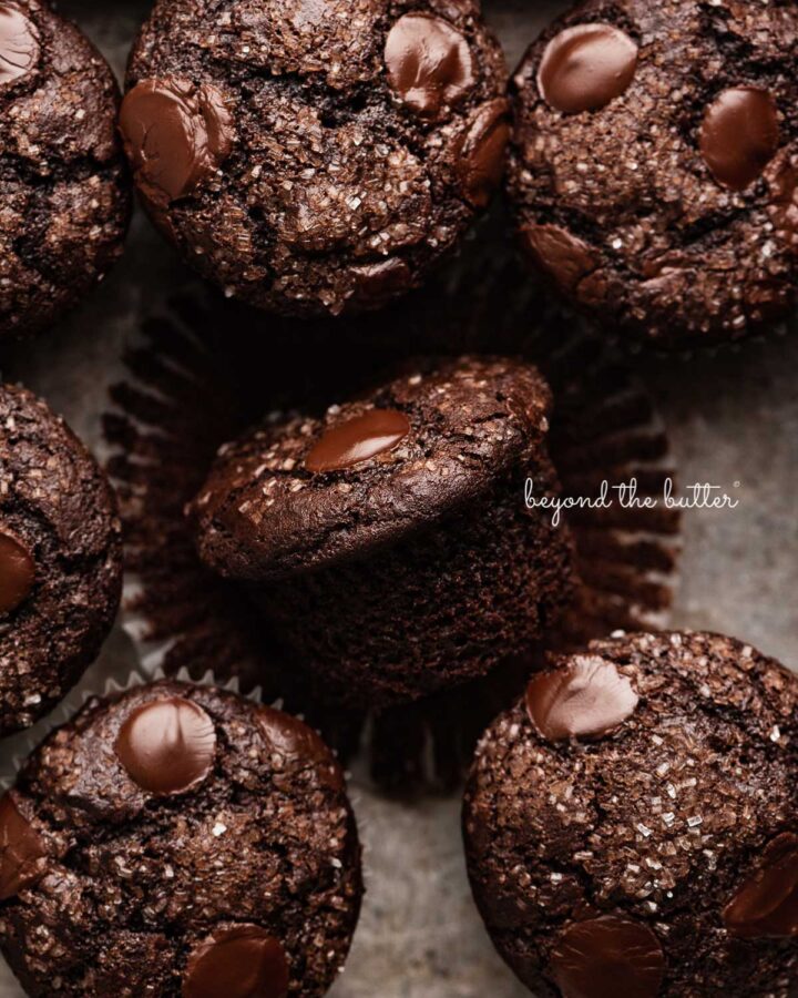 Double chocolate muffins in a vintage baking tin with one unwrapped.