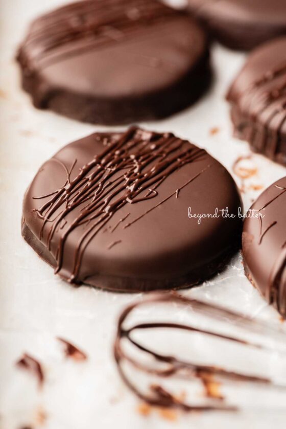 Chocolate dipped thin mints on wax paper lined baking sheet | © Beyond the Butter®