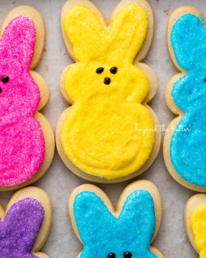Easter bunny cut out sugar cookies on a parchment paper lined baking sheet.