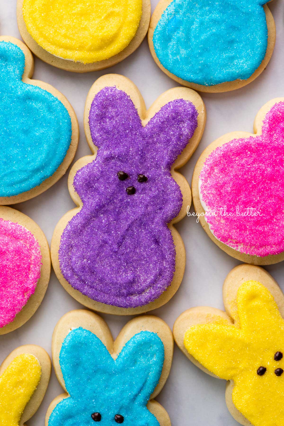 Easter bunny cut out sugar cookies on a marbled background | © Beyond the Butter®