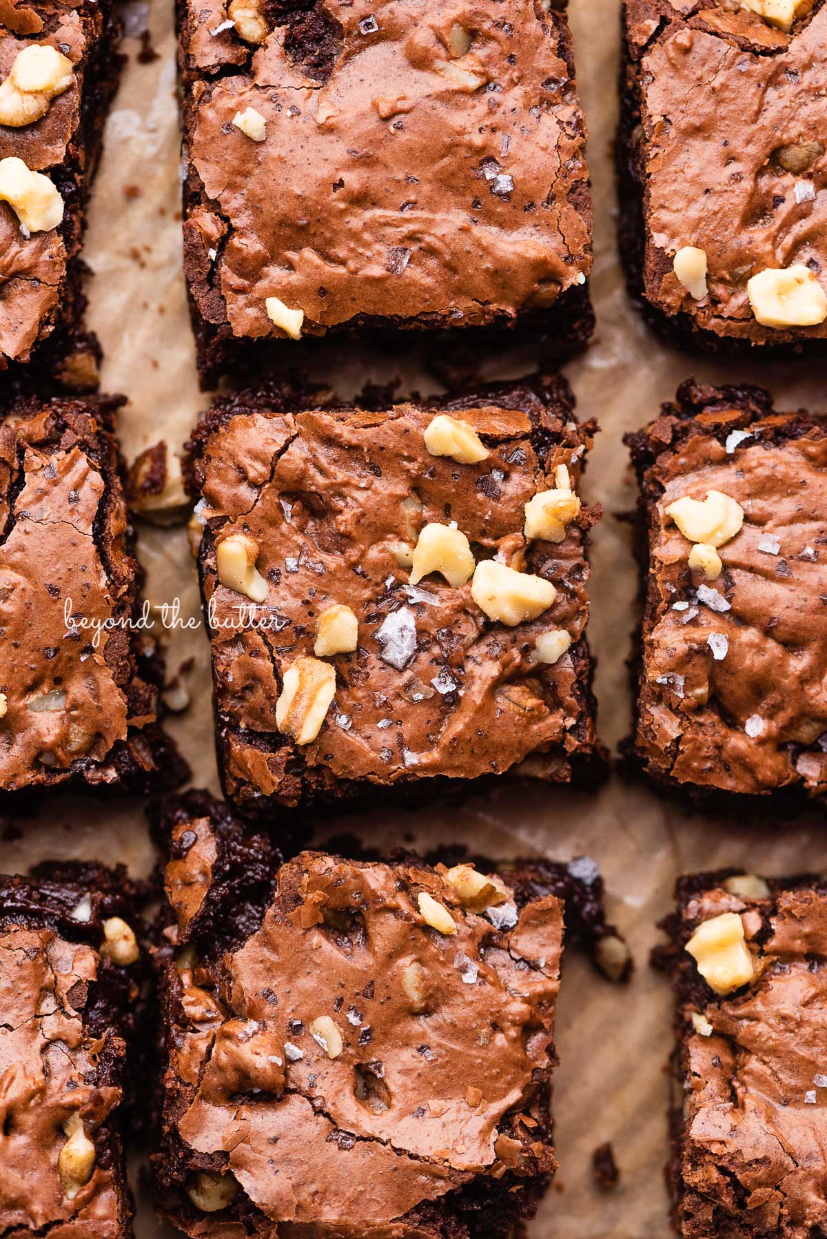 Better than box mix fudgy brownies on a parchment paper lined baking sheet | © Beyond the Butter®